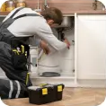 Plumber working under a kitchen sink