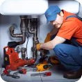 Plumber repairing pipes under a sink